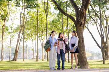 Fototapeta premium Three schoolgirls chat and collaborate, deciding on a project topic to showcase to their teacher.