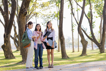 Fototapeta premium Three schoolgirls chat and collaborate, deciding on a project topic to showcase to their teacher.