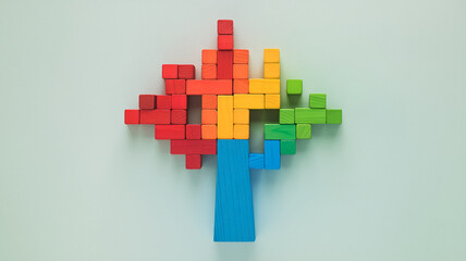 Obraz premium Colorful wooden blocks arranged as a tree on a light-green background, showcasing creativity, growth, and building concepts