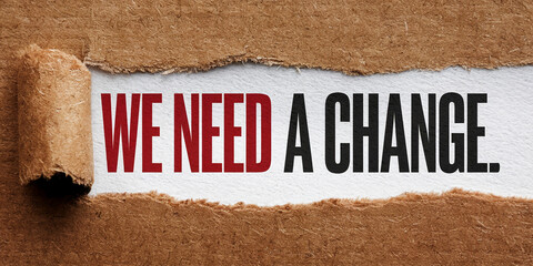 Torn brown paper reveals text: "WE NEED A CHANGE" in red and black, conveying a message of social or political transformation and the need for improvement