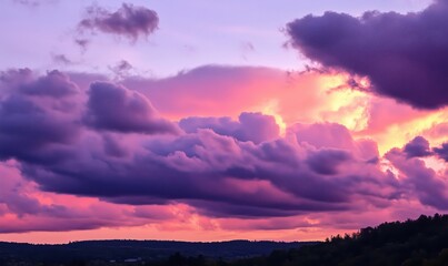 Obraz premium Stunning sunset sky with vibrant purple and pink clouds over rolling hills