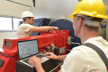 Mechanics repair a machine in a modern industrial plant - profession and teamwork