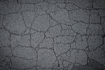 Dark grey asphalt road with cracks