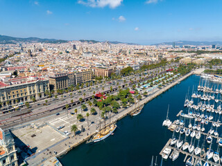 Aerial view of Barcelona port with yachts, palm-lined promenades, and the historic city center on a...