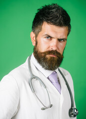 Portrait of serious doctor with beard and mustache in medical gown with stethoscope in hospital. Bearded physician in white uniform with stethoscope. Healthcare, medicine, treatment and medical staff.