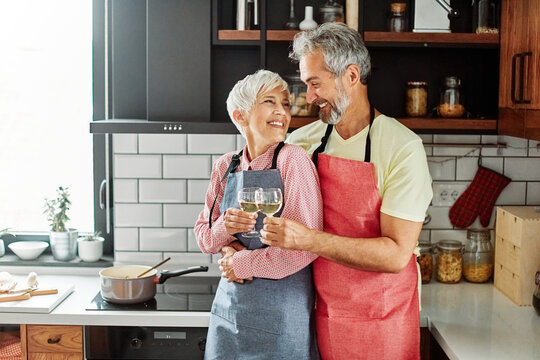 love kitchen senior woman couple home portrait wine glass celebration retirement toast wineglass alcohol holiday beverage red romantic anniversary dating toasting valentine eve