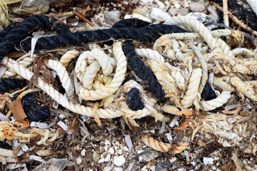 Weathered nautical ropes on pebble beach