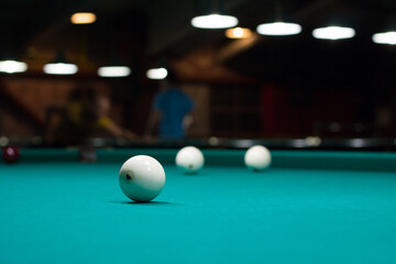 Russian billiard in club: white balls on green table cloth