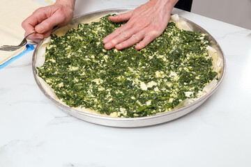 woman in kitchen preparing spinach pie