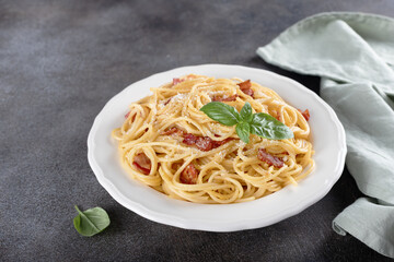 Italian pasta carbonara with ingredients bacon, cheese, eggs, garlic on dark background. Italian food.