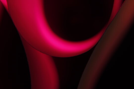 Papel de color para regalos, borroso formando aros y curvas geom&eacute;tricas forma un original dise&ntilde;o abstracto con fondo negro.