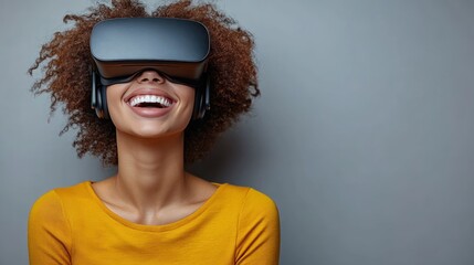 Woman wearing a virtual reality headset smiling against a gray background.