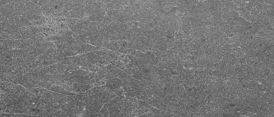 Gray wall with many cracks holes scratches and marks. wall is made of concrete and has a rough texture as an abstract texture background for template pages and banners