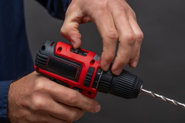 The man uses a cordless screwdriver.