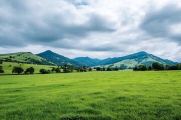Obraz premium Serene Green Hills Landscape - Tranquil landscape, symbolizing peace, nature, growth, serenity, and freedom. A picturesque view of rolling hills and a lush green field under a partly cloudy sky