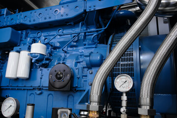 a pressure gauge is attached to a silver tube on a large diesel engine