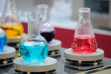Mixers in the laboratory stir multi-colored liquids in chemical flasks. Analytics medicine...