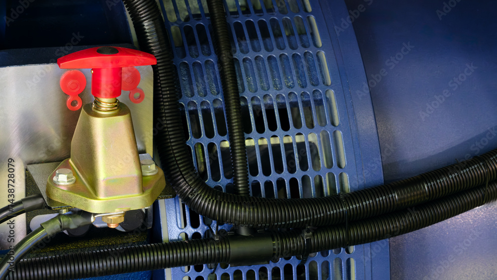 Poster red and black switch is attached to the blue and black machine's alternating current electric generator. The switch is located on the side of the machine and is the control element for the machine.