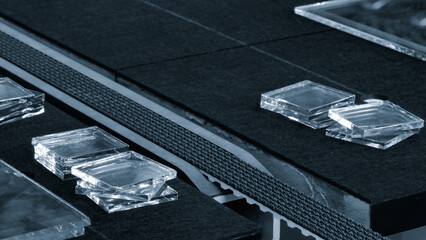 A black table with a blue border and a number of clear glass pieces on it. The table is made of...