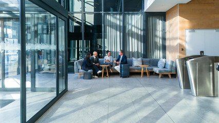 Business people, airport lounge and luggage for travel in first class, international relations officer and meeting. Networking, adventure and group on couch, conversation and layover with suitcase