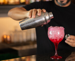 Bartender prepares preparing refreshing tequila sunrise drink - cocktail tequila sunrise with...