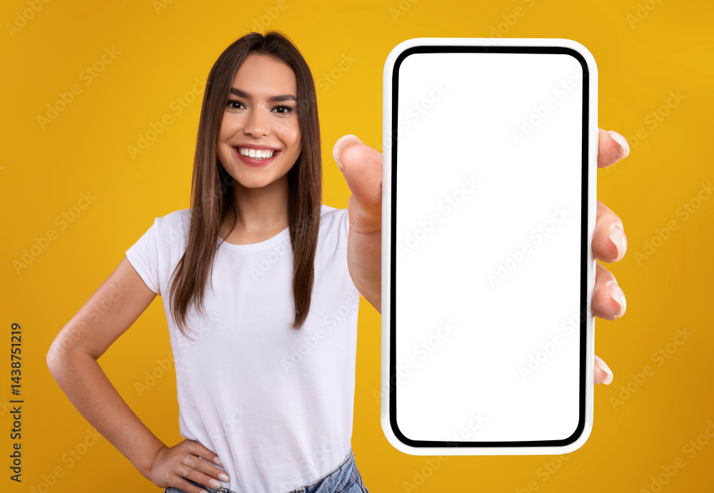 Aufkleber Mobile App Advertisement. Excited Woman Showing White Empty Smartphone Screen Recommending App Posing Over Orange Studio Background, Smiling To Camera. Check This Out, Cellphone Display Mock Up