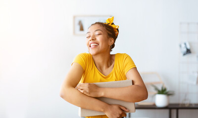 Satisfied with Present. Excited happy black woman embracing cardboard box with holiday gift,...