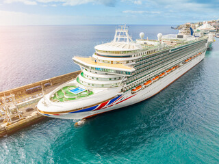 Luxurious cruise ship sailing through clear blue waters on a sunny day, offering unforgettable...