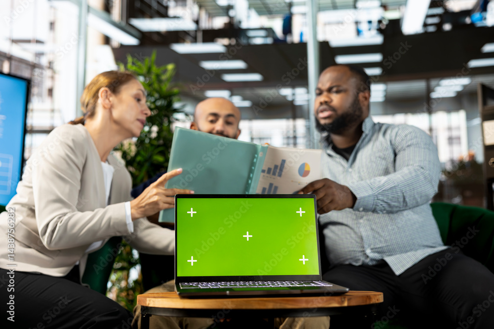 Poster green screen laptop in front of employees checking progress done on customer commissioned project. c