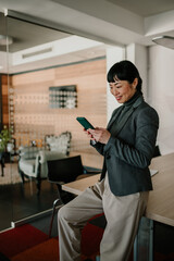 Asian businesswoman using smartphone in modern office