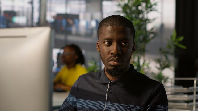 Upbeat software engineer utilizing cloud computing resources to train and deploy large scale machine learning models. Jolly man monitoring company systems, ensuring their reliability, camera A