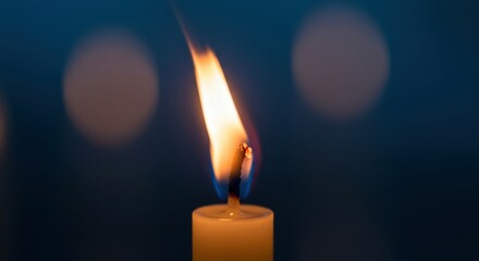 Single candle flame burning with warmth and intimacy.
