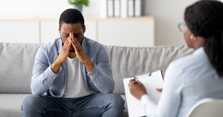Desperate black man suffering from nevrous breakdown or depression, having session at...