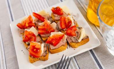 Small sandwiches with meat paste and slice of fresh tomato are laid out and cooked on small plate. Hearty homemade snack for group of friends