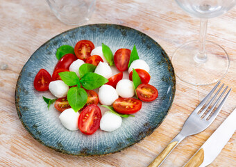 Light refreshing caprese salad of tender mozzarella and ripe tomatoes. Italian style appetizer or entree