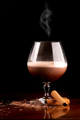 chocolate cocktail glass with cognac and cinnamon coffee with chocolate shavings and cinnamon stick...