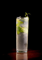 drink mojito with mint ice from the front on a wooden table and black background