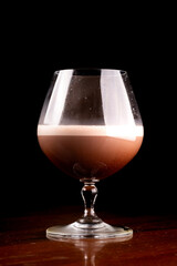 glass of chocolate cognac cocktail with coffee isolated on black background