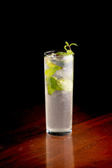 mojito drink with mint ice on wooden table and black background