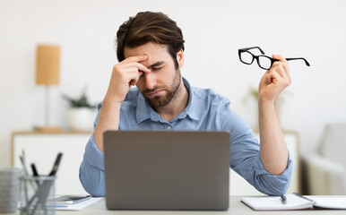 Eyes Fatigue. Tired Man At Laptop Massaging Nosebridge Holding Eyeglasses Exhausted After Work On...