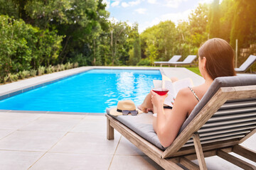 Reading, woman and cocktail at hotel pool for fantasy, relax and freedom for luxury holiday. Water,...