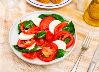 Light refreshing caprese salad of tender mozzarella and ripe tomatoes. Italian style appetizer or entree