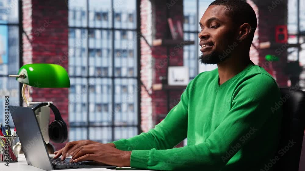 Poster african american male teleworker completing spreadsheets on laptop, entering numerical data into cel