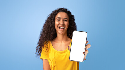 Fototapeta premium Gotcha. Positive brunette woman pointing finger at camera and laughing, joyful young curly lady indicating somebody and having fun, standing isolated over purple studio background, copy space.