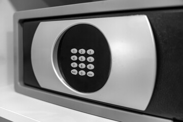 Small metalic safe with a combination lock for storing valuables with an open door cabinet white...