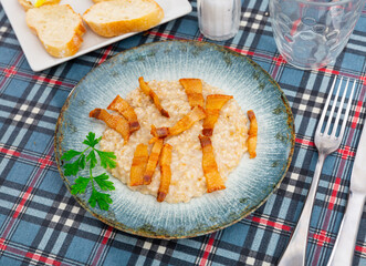 Delicious oatmeal porridge served with fried lard on platter