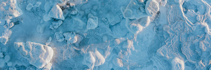 Top view of the icy shore. Winter aerial photograph of ice floes on the coast. Amazing northern...
