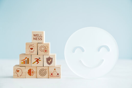 Hands holding wooden cube blocks with wellness icons, positive mental health, life balance concept