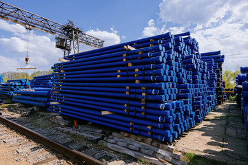 Stack of cast iron pipes in loading area waiting for transportation