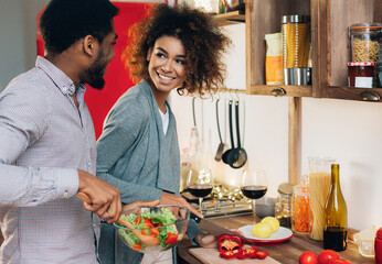 African-american couple in love cooking vegetarian lunch together in kitchen, copy space